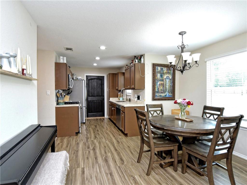 504 West 2nd Street Elgin, TX 78621 - Photo 20 of 22 a kitchen with a dining table chairs stainless steel appliances and cabinets