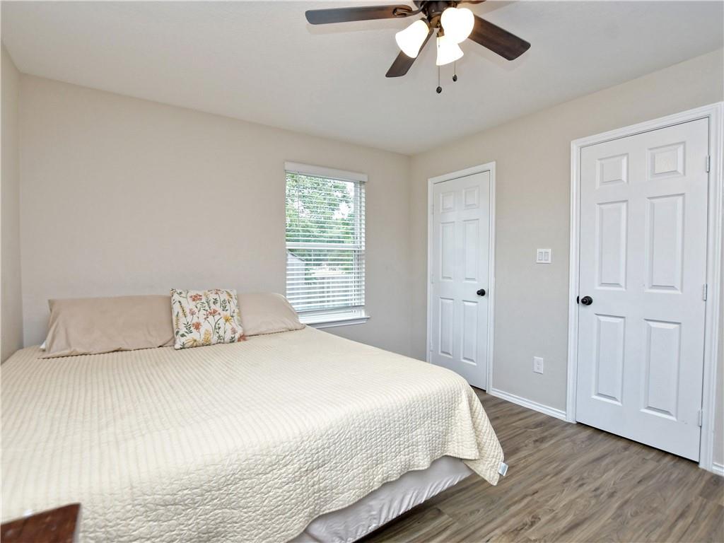 504 West 2nd Street Elgin, TX 78621 - Photo 7 of 22 a bedroom with a large bed and a chandelier
