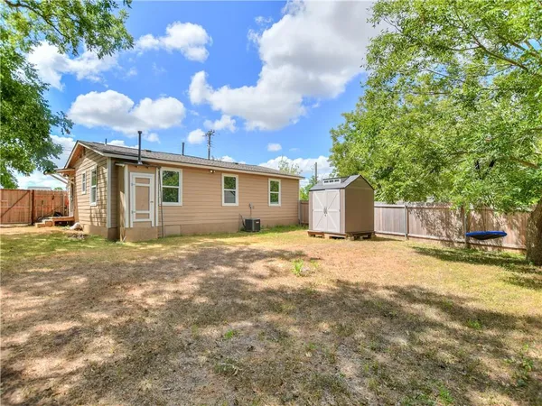 a view of a house with a backyard and a tree
