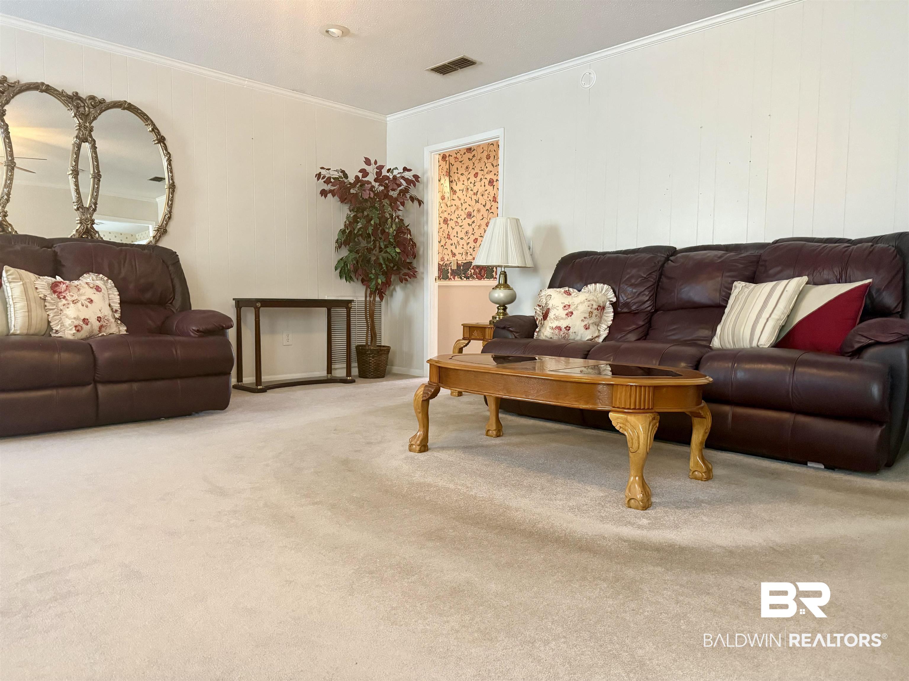 215 Young Street Brewton, AL 36426 - Photo 3 of 25 Living area featuring carpet flooring, crown molding, and wooden walls