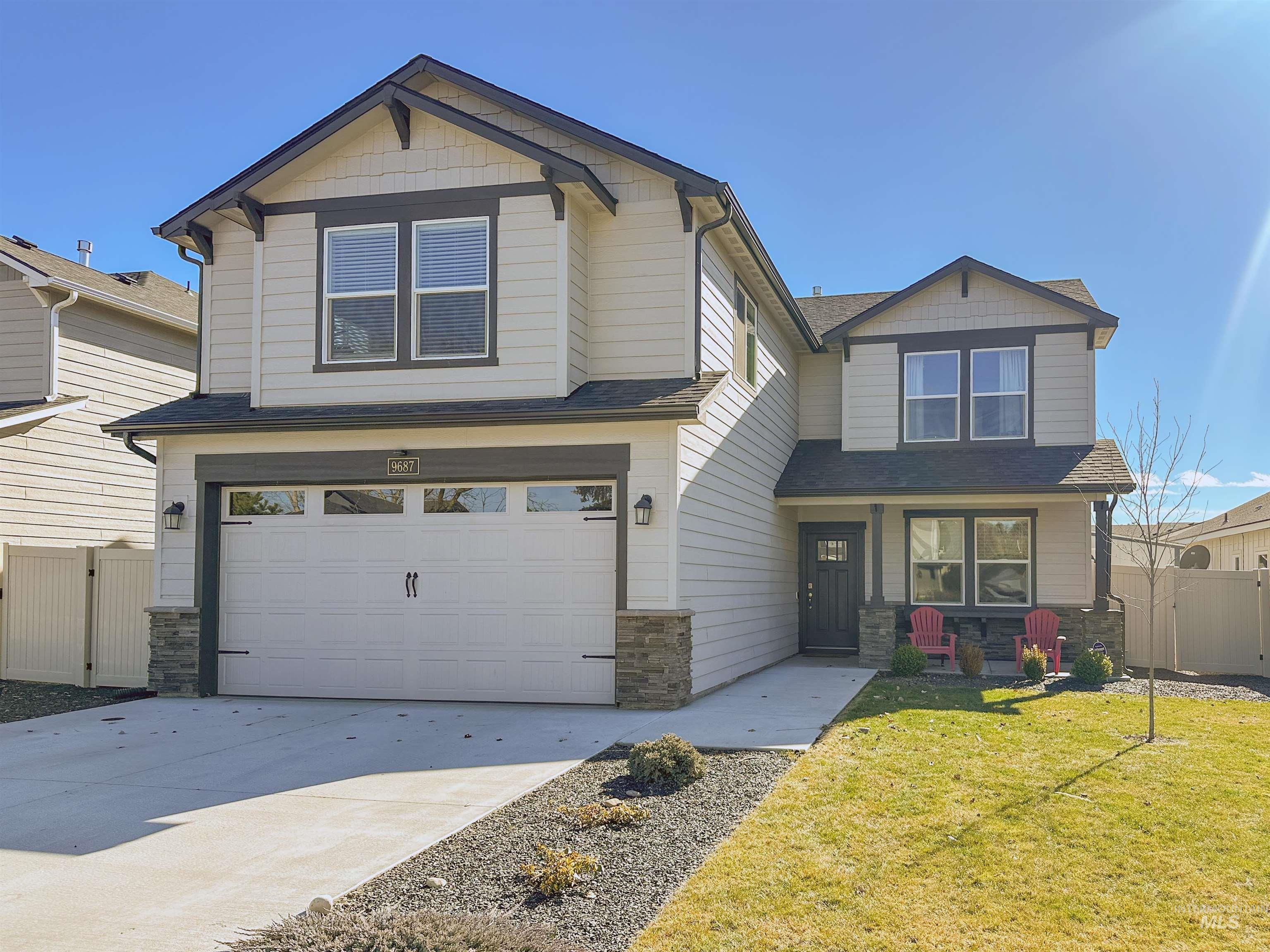 9687 West Arnold Road Boise, ID 83714 - Photo 2 of 37 Two-story residence featuring light-colored siding with dark trim, stone veneer accents, and an attached two-car garage