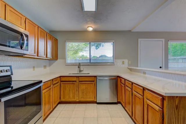 a kitchen with stainless steel appliances granite countertop a sink and dishwasher a stove top oven with wooden floor