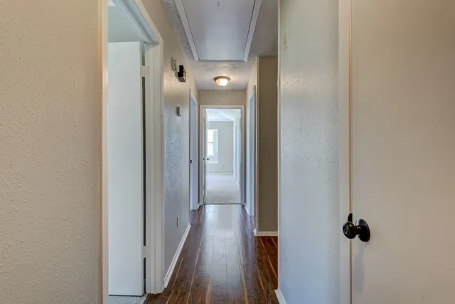 a view of a hallway with wooden floor