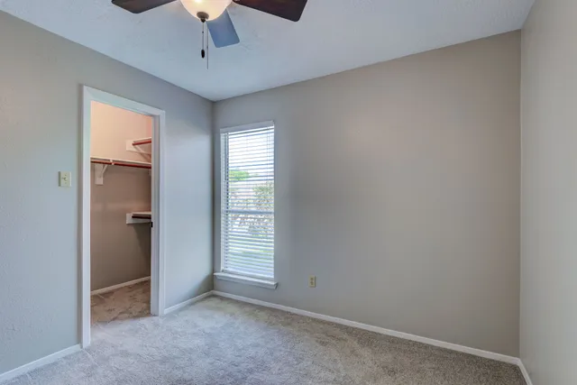 an empty room with windows and cabinet