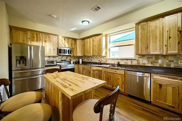 a kitchen with a refrigerator a stove a sink dishwasher and microwave with wooden floor