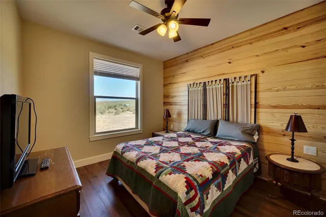 a bedroom with a bed tv and a window