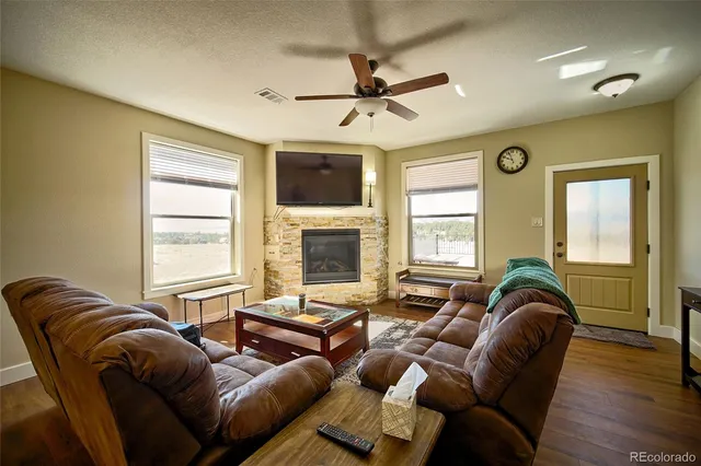 a living room with furniture ceiling fan and a window