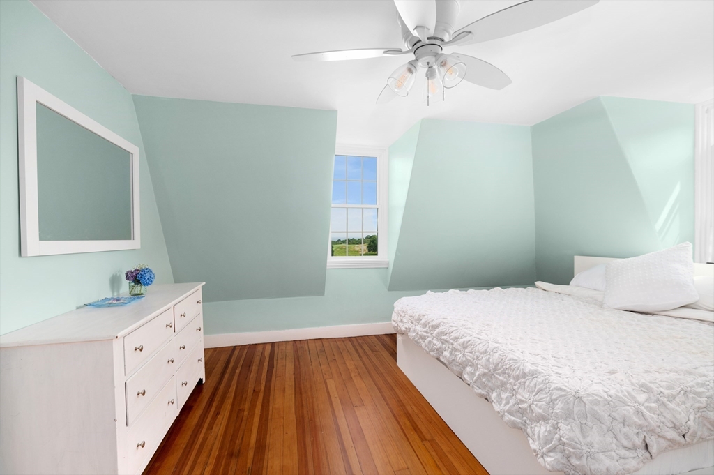 31 Beach Road Gloucester, MA 01930 - Photo 25 of 43 a bedroom with a bed and a chandelier fan