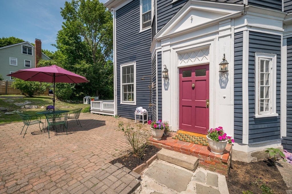 31 Beach Road Gloucester, MA 01930 - Photo 6 of 43 a view of a patio with a table and chairs under an umbrella