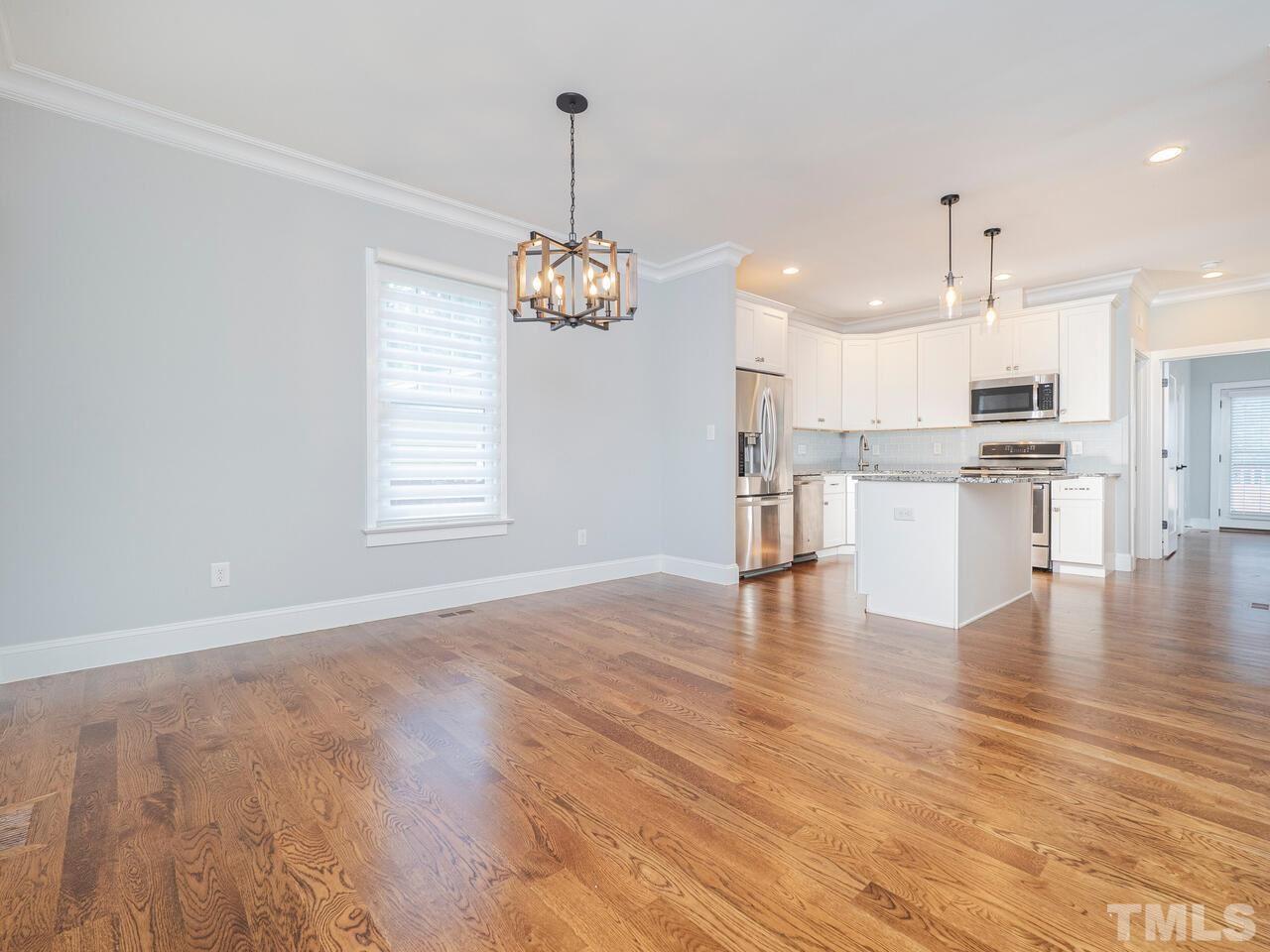 910 South Person Street Raleigh, NC 27601 - Photo 3 of 30 a view of a kitchen with a sink dishwasher wooden cabinets and a dining table