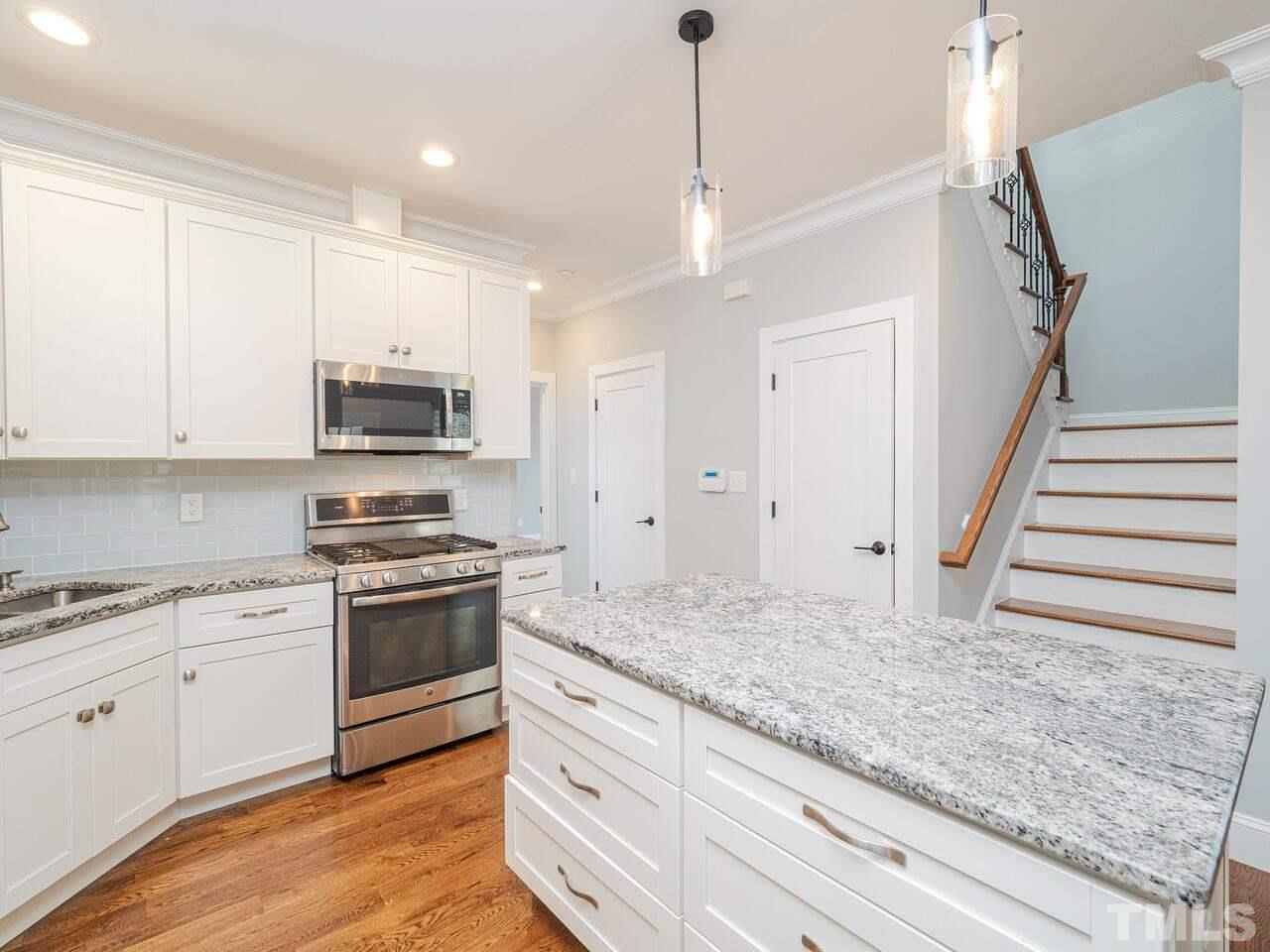 910 South Person Street Raleigh, NC 27601 - Photo 9 of 30 a kitchen with stainless steel appliances granite countertop a sink a stove and a refrigerator