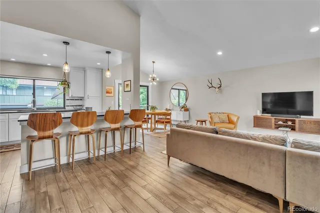 a living room with furniture a flat screen tv and kitchen view