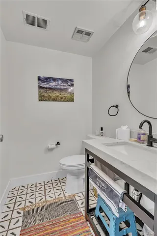 a bathroom with a sink a toilet and a mirror