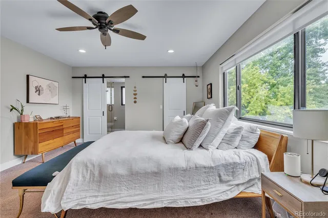 a bedroom with a bed a window and a chandelier