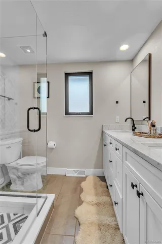 a bathroom with a double vanity sink a mirror and a shower
