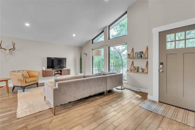 a living room with furniture a flat screen tv and a large window