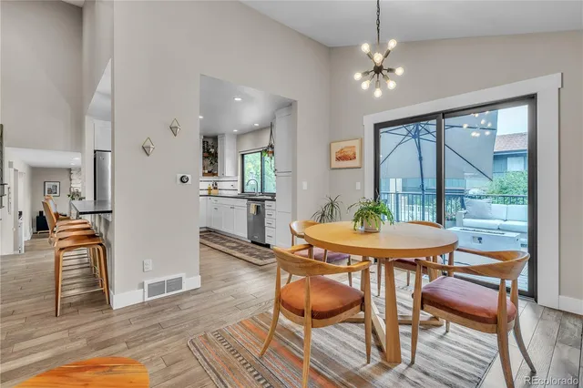 a dining room with furniture a chandelier and wooden floor