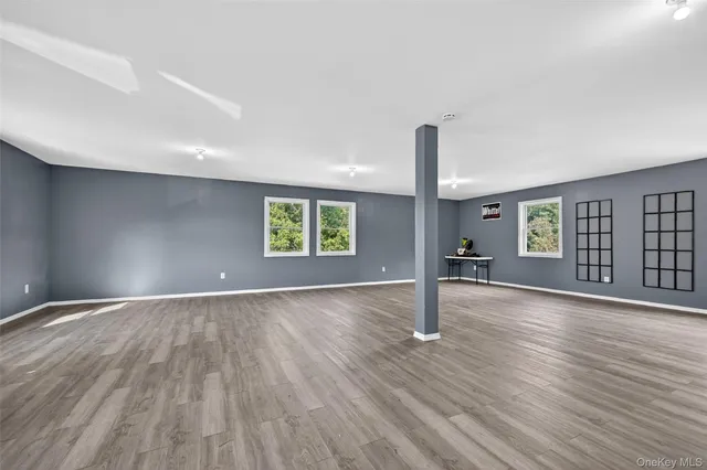 an empty room with wooden floor and window