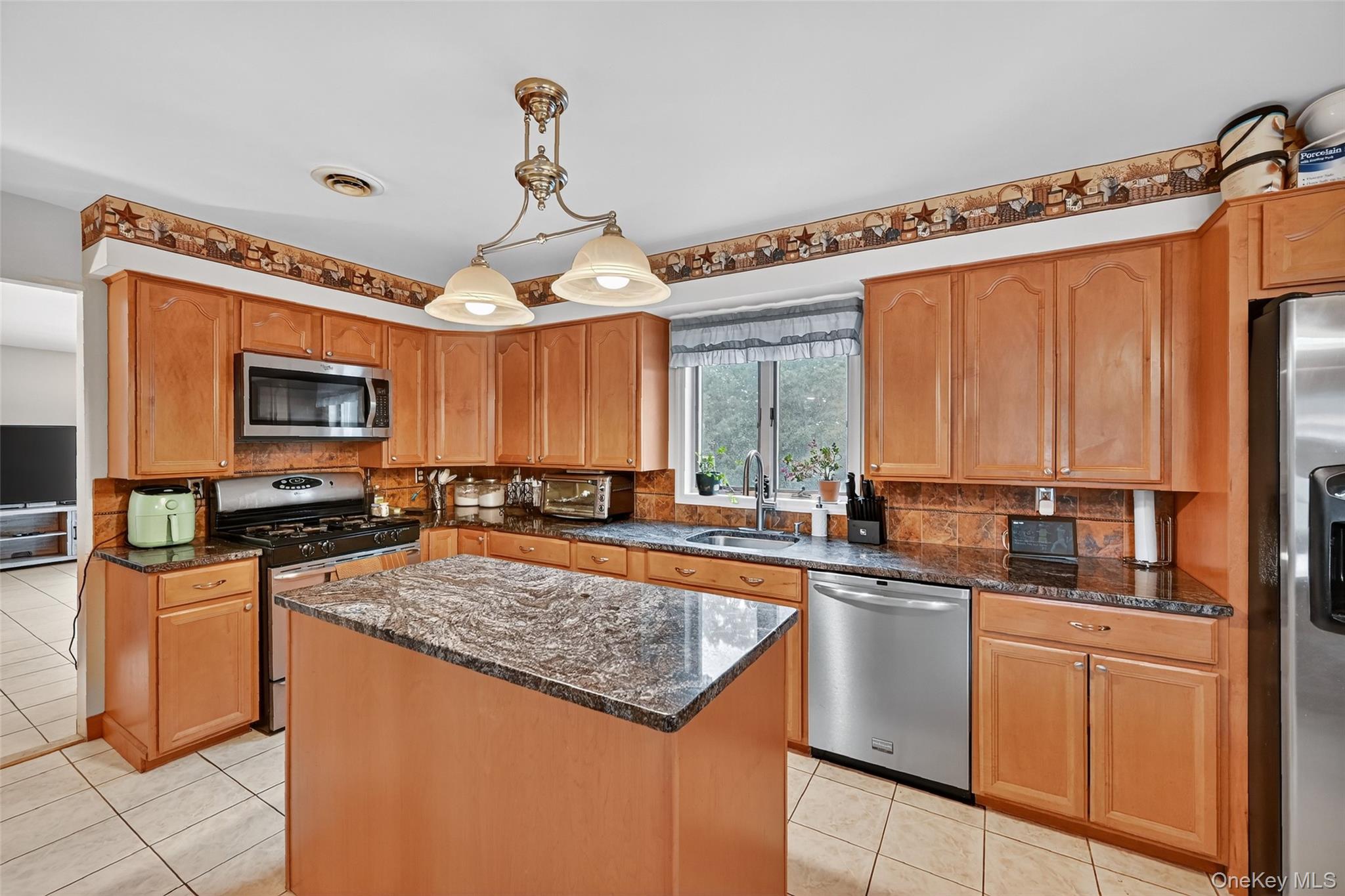 334 Greeves Road New Hampton, NY 10958 - Photo 7 of 45 a kitchen with stainless steel appliances granite countertop a stove top oven a sink dishwasher a dining table and chairs with wooden floor