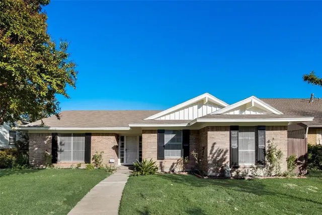 a front view of a house with a garden and plants