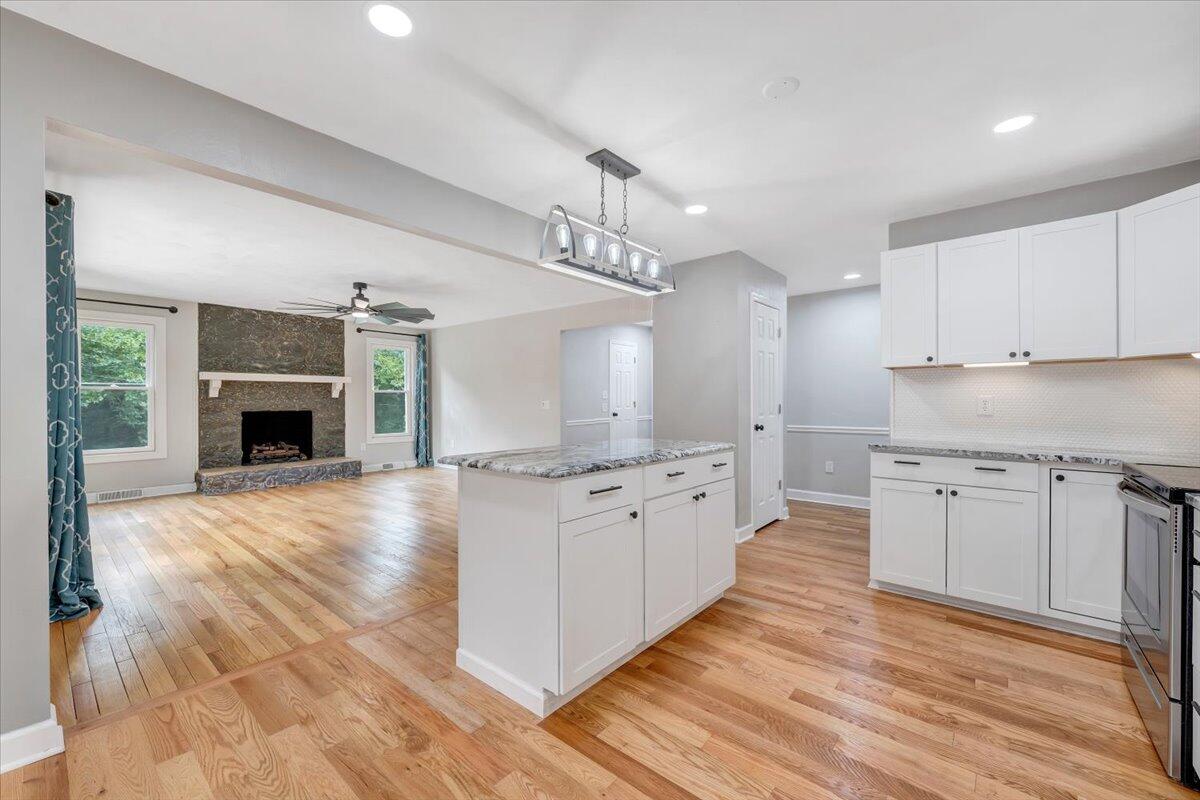 422 Willow Creek Road Rocky Mount, VA 24151 - Photo 21 of 70 a large kitchen with granite countertop a stove top oven a sink dishwasher and a fireplace with wooden floor