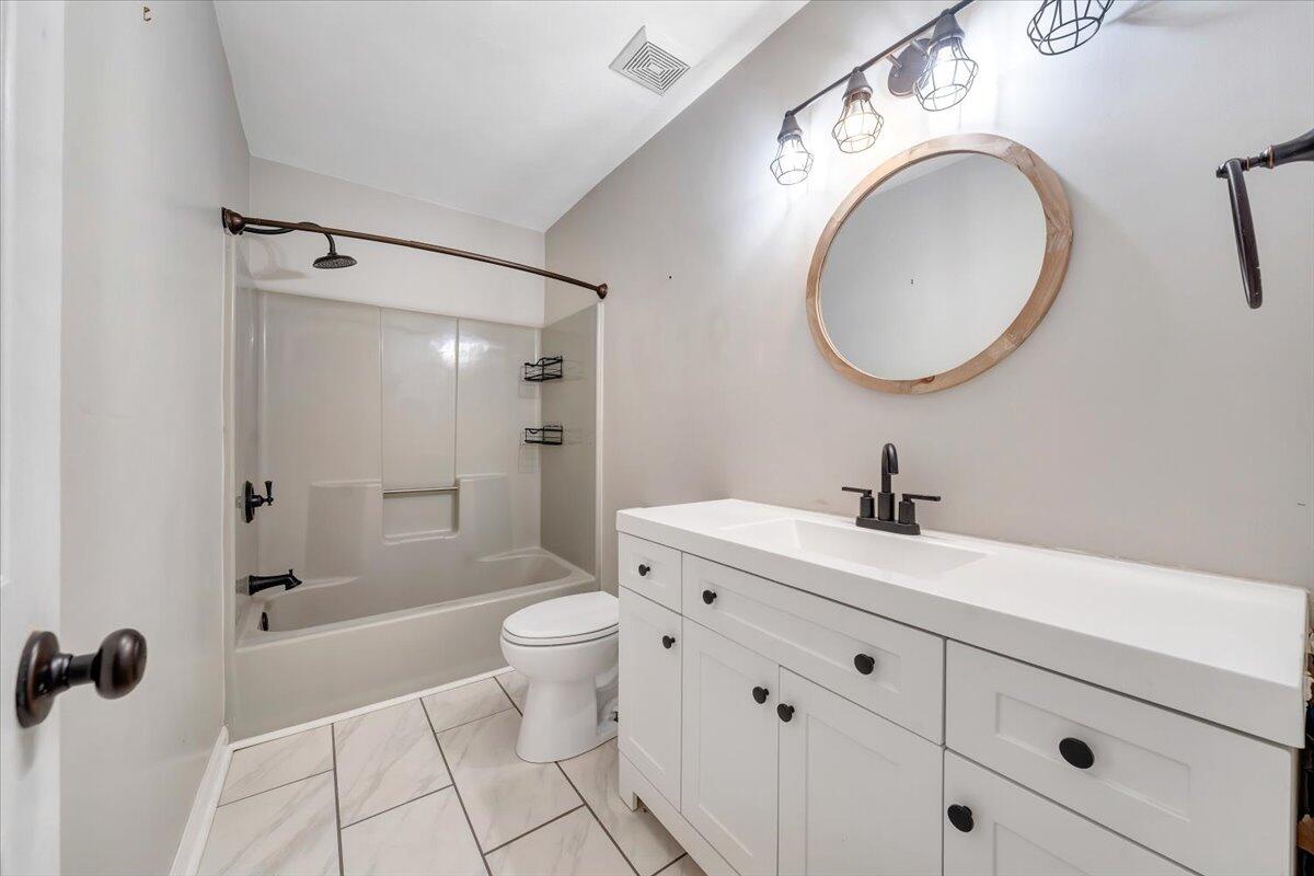 422 Willow Creek Road Rocky Mount, VA 24151 - Photo 39 of 70 a bathroom with a granite countertop sink toilet a mirror and shower
