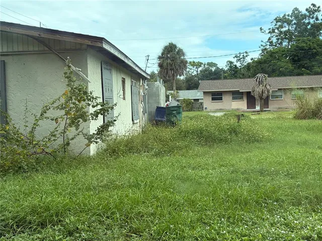 a backyard of a house with table and chairs