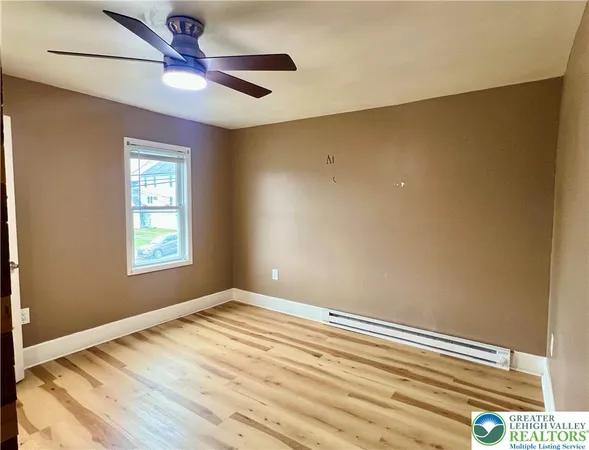 a view of an empty room with a fireplace and a chandelier