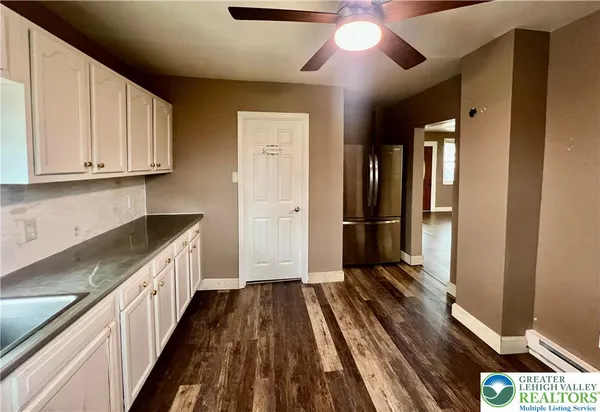 a kitchen with a sink and wooden floor