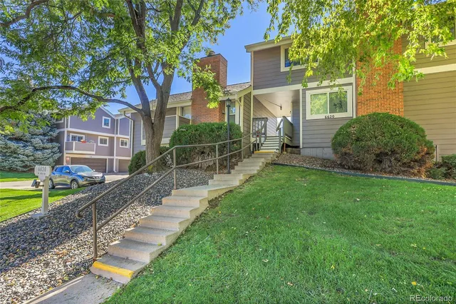 a view of a house with a yard and a patio
