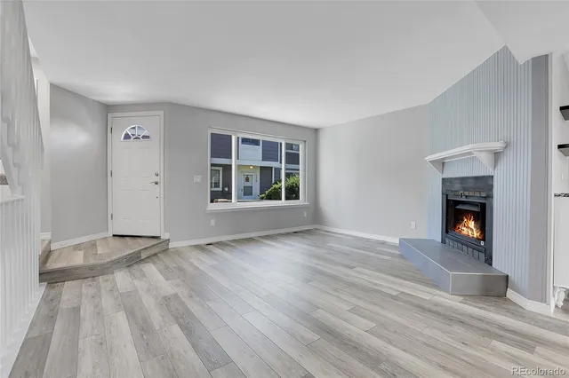 an empty room with windows and fireplace