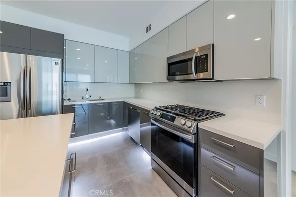 a kitchen with stainless steel appliances a stove a microwave and a refrigerator
