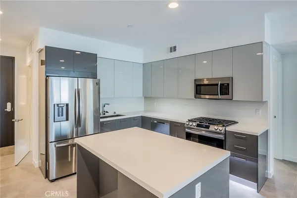 a kitchen with stainless steel appliances a microwave a stove and refrigerator