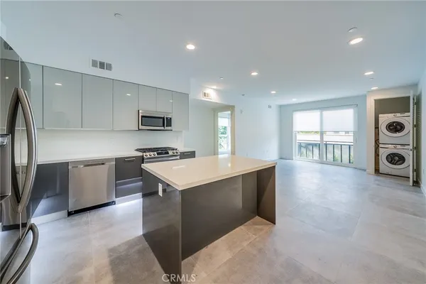 a large kitchen with stainless steel appliances granite countertop a stove a sink and a refrigerator