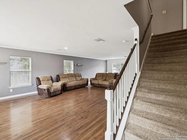 a view of a livingroom with wooden floor and furniture