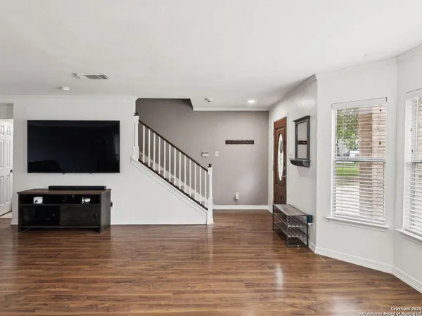 a kitchen with granite countertop a stove a sink dishwasher and a refrigerator with wooden floor