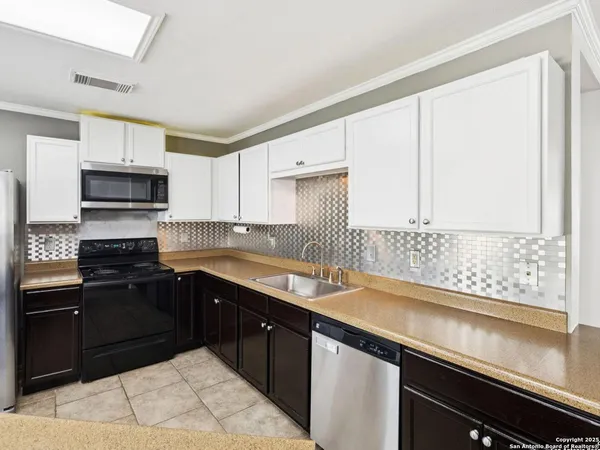 a kitchen with a stove a sink a microwave and cabinets