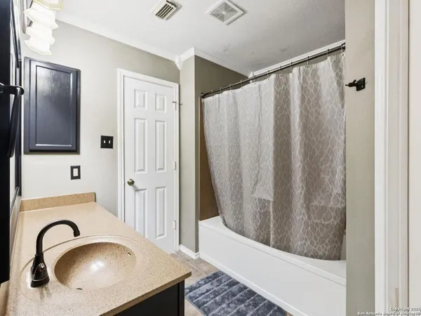 a spacious bedroom with a bed and a ceiling fan