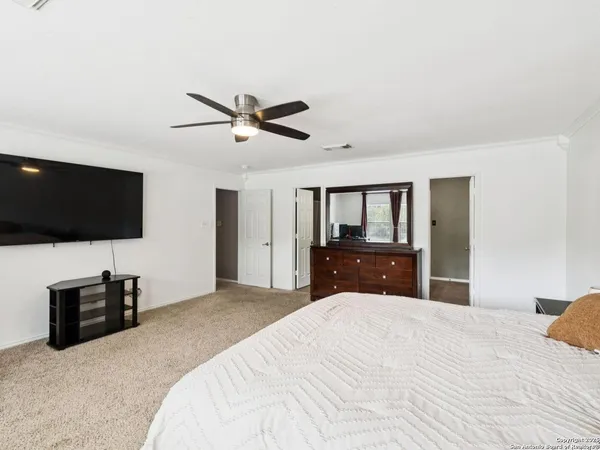 a spacious bedroom with a bed couch and a large window