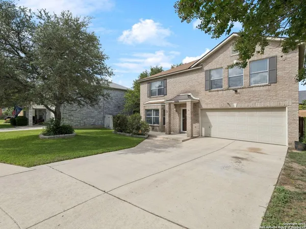 a front view of a house with a garden and yard