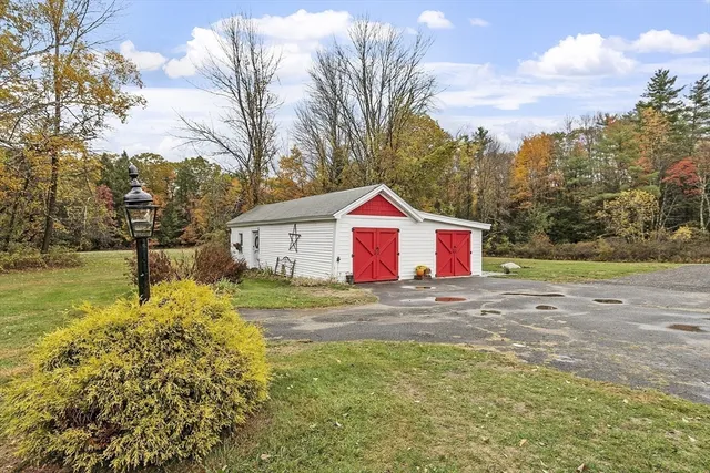 a front view of house with yard and trees in the background