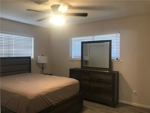 a bedroom with a bed and a flat tv screen on dresser