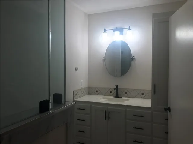 a bathroom with a sink and mirror with toilet