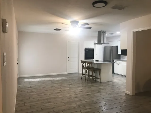 a view of a kitchen with cabinets and wooden floor