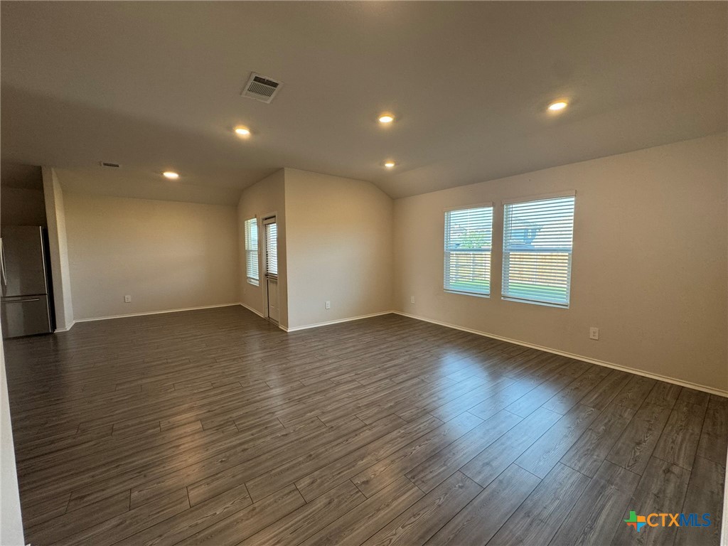 208 Ida Loop Seguin, TX 78155 - Photo 4 of 16 an empty room with wooden floor and windows