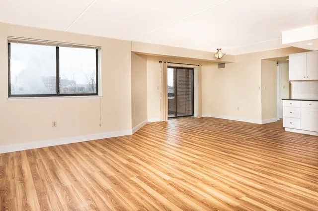 a view of a room with wooden floor and white walls