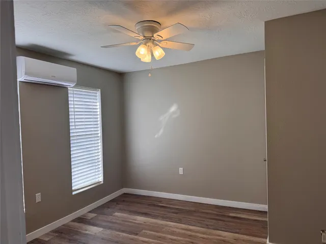 an empty room with window and wooden floor