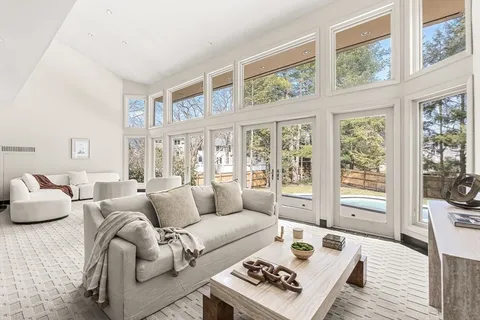 a living room with furniture and a window with garden view