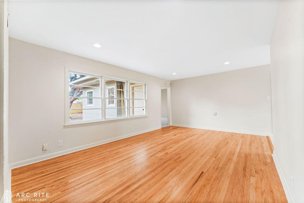 4015 37th Street Lubbock, TX 79413 - Photo 11 of 30 a view of an empty room with wooden floor and a window