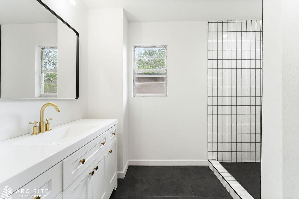 4015 37th Street Lubbock, TX 79413 - Photo 17 of 30 a bathroom with a sink a mirror and shower